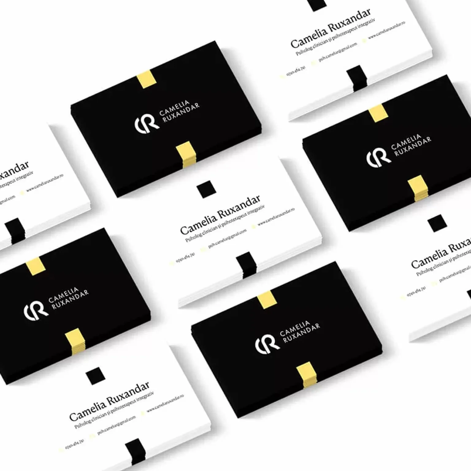 Stack of black and white Camelia Ruxandar business cards with a yellow accent edge